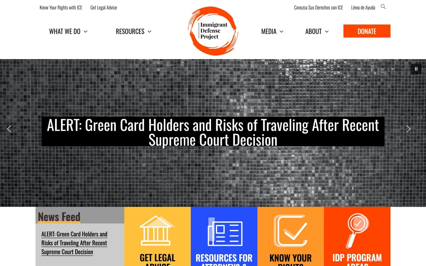 Screenshot of the Immigrant Defense Project homepage with a bilingual utility navigation and an alert headline about green card holder travel risks